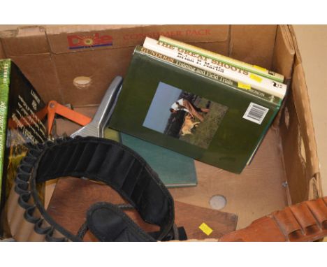 Two leather cartridge belts; a hunting whip; a boxed gun cleaning kit; and a small collection of sporting books.