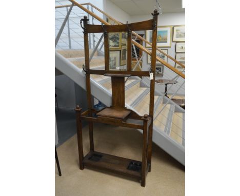 An Arts &amp; Crafts style oak hall stand by Brough Bros, Liverpool, the upper section with mirror and six hooks, a hinged tr