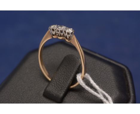 A three stone diamond ring, on yellow metal shank.