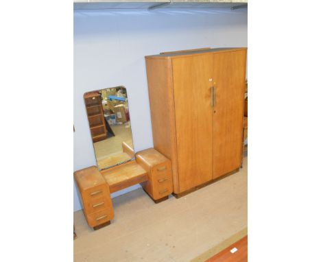 A mid 20th Century light oak wardrobe, the panelled doors opening to reveal hanging space, 184cms high; together with a match