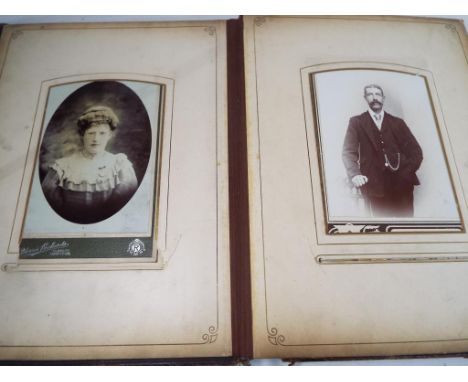 A good quality leather bound photograph album containing black and white portrait circa 1900 and a book entitled Hoppus's Pra