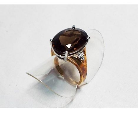 A lady's 9 carat gold dress ring set with 7 carat smoky quartz and diamonds to shoulders, size , approx weight 4.4 gm - Est £