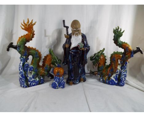A good quality Japanese ceramic figurine depicting a gentleman with a salt glaze finish on a wooden plinth, inscribed to the 