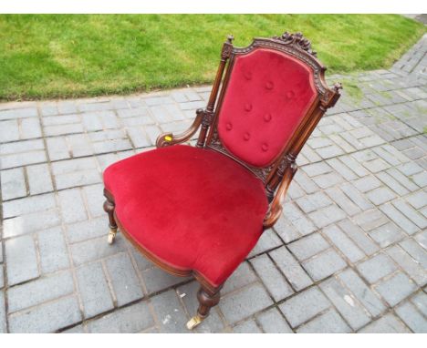 A highly carved occasional chair with upholstered seat and button back. Estimate £40 - £60