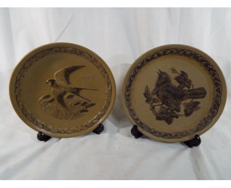 Poole Pottery - a pair of plaques decorated with depictions of birds and issued in a limited edition, 21 cm (diameter) - Est 