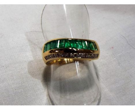 A lady’s 18ct gold ring marked 750 with baguette cut emeralds and diamonds forming a half eternity, approx. weight 5.3 grams,