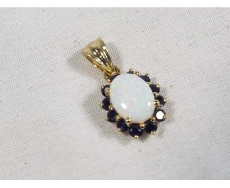 A hallmarked 9ct gold opal and sapphire pendant, approx. weight 1.3 grams, boxed - Est £25 - £40