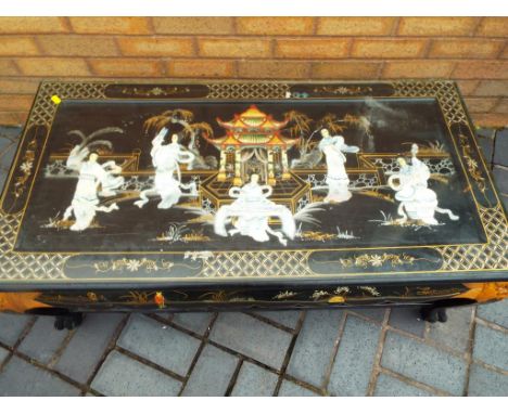 A carved glass top coffee table, inlaid pearl, hand painted and carved dragon legs, top and sides are inlaid with mother of p