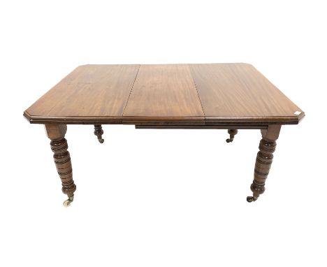 Edwardian mahogany wind out extending dining table, the top with canted corners over turned supports and brass and ceramic ca