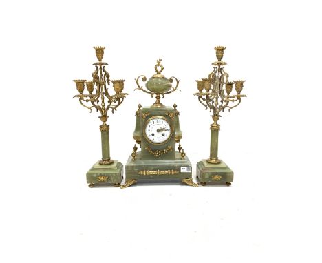 Late 19th century onyx and gilt three-piece clock garniture, the clock case surmounted by an urn shaped finial, over a white 