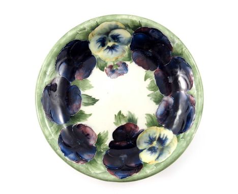 William Moorcroft, a Pansy on White plate, 1914, circular with everted rim, underglaze green signature and date, 21.5cm diame