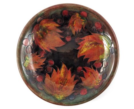 William Moorcroft, a Flambe Leaf and Berry plate, circa 1930, green brown ground with everted rim, impressed marks and facsim