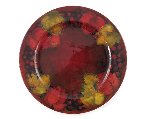 William Moorcroft, a large Flambe Leaf and Berry plate, circa 1936, red ground with broad rim, impressed marks, paper labels,