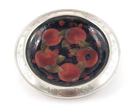 William Moorcroft, a Pomegranate on ochre silver rimmed dish, circa 1928, circular with everted rim, the silver marked sterli