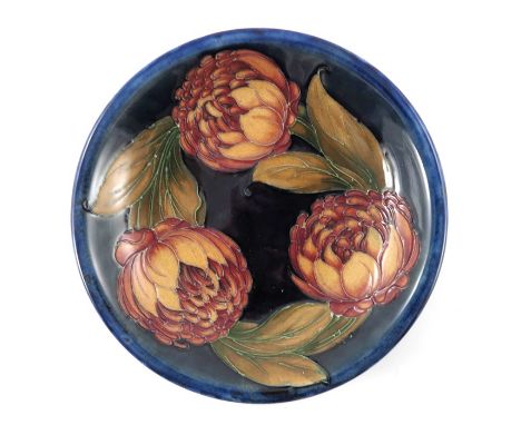 William Moorcroft, a Waratah plate, circa 1932, blue ground, impressed marks and facsimile signature, underglaze blue monogra