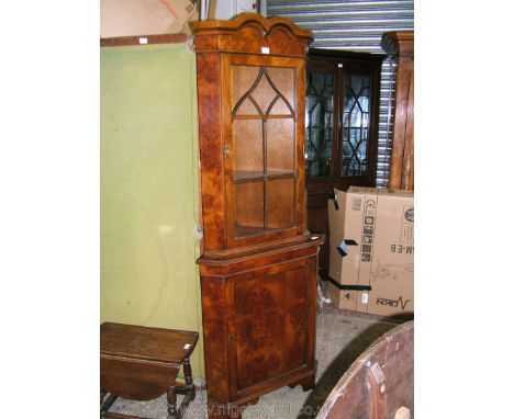 A good reproduction Pollarded Oak finished floor standing Corner Cabinet, having moulded top over single glazed door, over lo