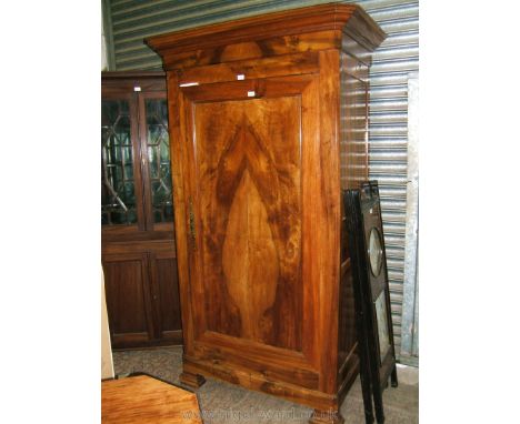 An elegant French Cherrywood Armoire having moulded cornice over a plain frieze, the single wide full-length door with mitred