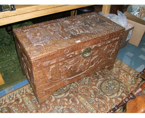A heavily carved Oriental Camphorwood Chest decorated with figures and floral motifs, on bracket feet. 39 3/4" wide x 23" hig