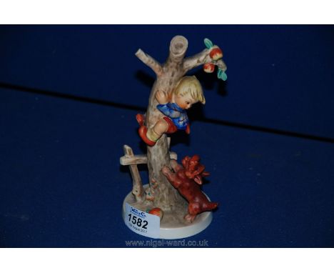 A Hummel West German figurine of a little boy climbing a tree with a dog at the base of the tree