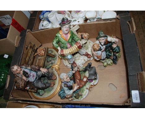 Four pieces of Capodimonte china including a man on a bench playing a squeeze box, a little girl reading her book to an old m