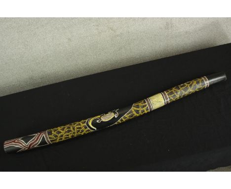 A heavily decorated Aboriginal didgeridoo. L.122 cm. 