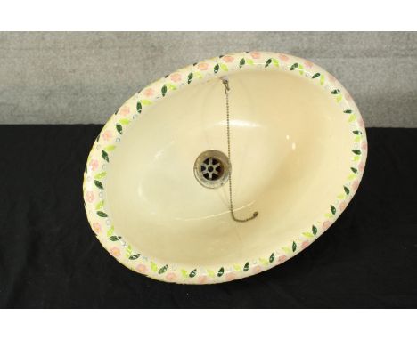 A deep and well decorated sink basin. With hand painted floral decoration around the rim. Maybe Victorian. H.22 x W.42 cm. 