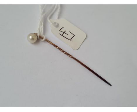 A real single pearl set stick pin in high carat gold
