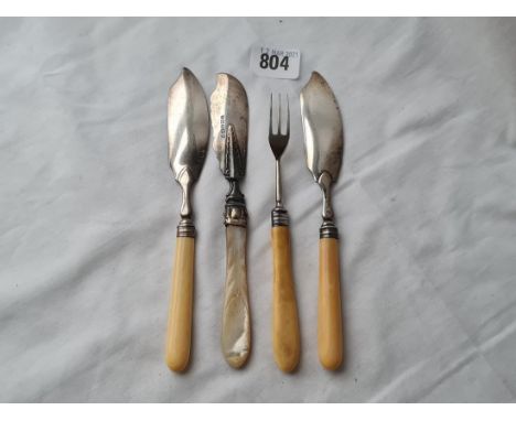 A pair of Georgian silver mounted butter knives with crested blades 1912 another with MOP handle and a pickle fork