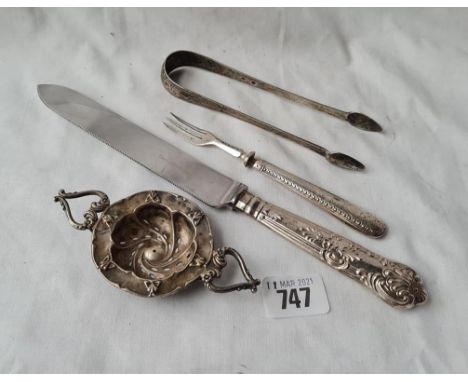 A pair of George III bright cut sugar tongs a foreign tea strainer a bread fork