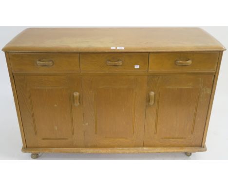 A 1960s Ercol sideboard with three drawers over bi fold doors and a single door, 77cm high x 121cm wide x 51cm deep Condition