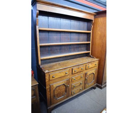 Georgian oak dresser cabinet with three shelf top over a base with six drawers and two panelled doors raised on bracket feet,