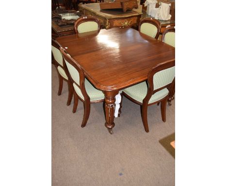 Victorian mahogany extending dining table raised on fluted legs with ceramic casters, together with two extension leaves, tab