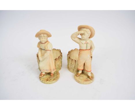 Pair of Royal Worcester figures of a boy and a girl with fern pots behind (2)