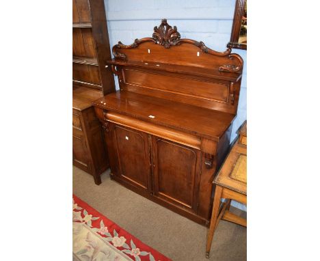 Victorian mahogany chiffonier of typical form with single shelf back, carved pediment and a base with frieze drawer and two p