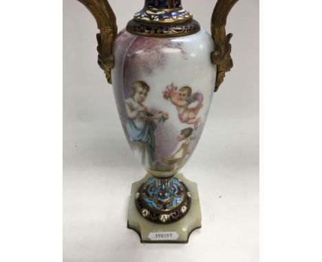 A 19th century sevres style enamel vase finely detailed with figures and cherubs in a landscape view With gilt mask handles o