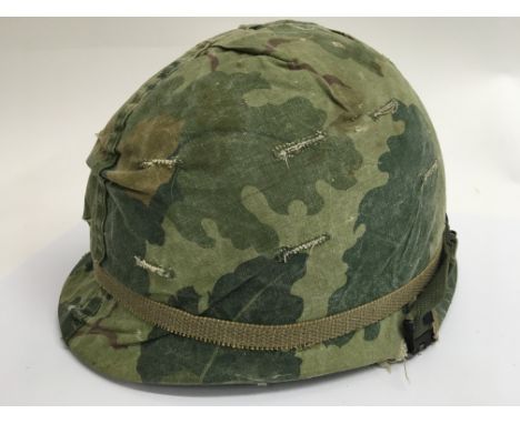 A Vietnam Era US M1 helmet and liner with "Mitchell" reversible camouflage cover