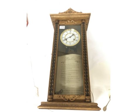 An oak wall clock Vienna type with visible pendulum.