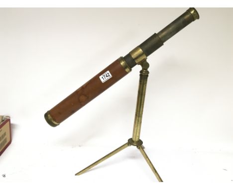 A 19th century telescope with a lacquered brass tripod stand.