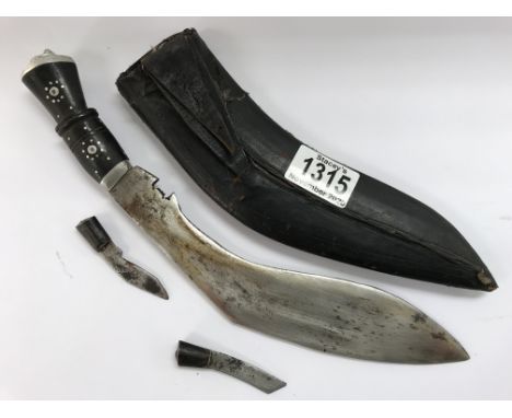 An Indian kukri knife in scabbard with skinning knife and sharpener and a similar knife with straight blade and scabbard