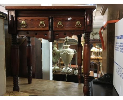 A small side table fitted with two drawers on turned legs