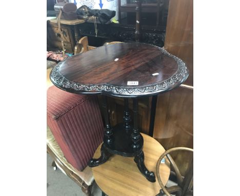 A Brazilian hardwood carved top tripod table.