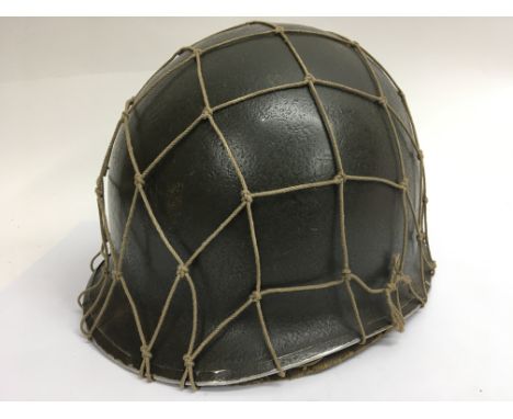 A WW2 US helmet with Capac liner and Cam net. Front seam Swivel Bale ( loops missing) with period painted Captains bars on th
