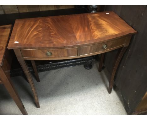 A reproduction mahogany side table fitted with two drawers, approx 85cm x 46cm x 77cm.