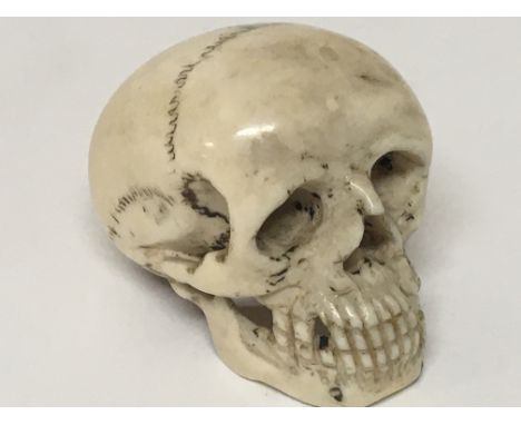 A 19th century ivory carving in the form of a skull height 4cm