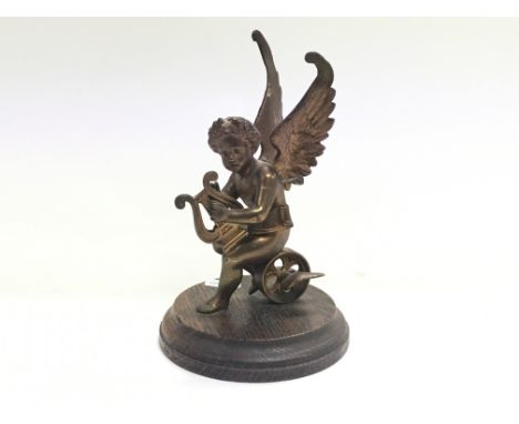 A spelter car mascot figure of a cherub playing a lyre, on stand