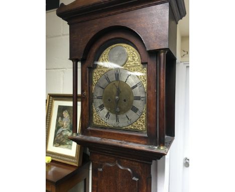 A oak 8 day long case clock the Arched brass dial with Roman numerals.
