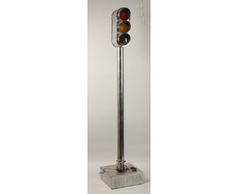 AN UNUSUAL FRENCH POLISHED STEEL CYCLING PROFICIENCY TRAFFIC LIGHT, with red, amber and green lights, on a column support, wi