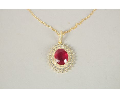 A SILVER GOLD PLATED RUBY PENDANT AND CHAIN.