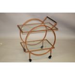 A TWO TIER METAL AND GLASS DRINKS TROLLEY on four wheels.