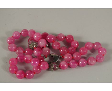 A STRING OF FIFTY PINK JADE AND DIAMOND BEADS. 60cms long.